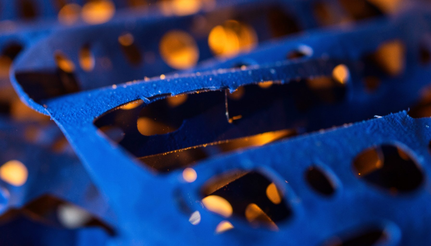 Close-up of film reel strips layered over each other, warm amber light glowing through the perforations